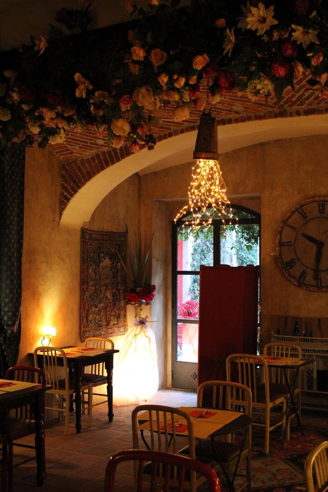 Angolo della sala con il soffitto coperto di fiori, l'arazzo e il grande orologio.